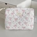 Detalle de neceser acolchado con lazo rosa, motivos florales y etiqueta de tela pequeña - Clutch Bag
