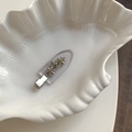 Barrette fleurie en métal avec strass colorés posée sur un plateau en forme de coquille - Transparent