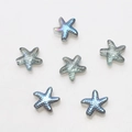 Macro view of blue-grey starfish glass beads with dotted texture and iridescent glow - Semi-transparent Blue
