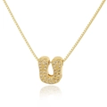 Detailed close-up of a gold U-shaped pendant necklace with sparkling micro-pave crystals - Letter U