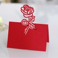 Elegant red laser-cut place card with hollow rose design for wedding table setting - Pearlescent Red