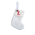 Detail of white knitted Christmas stocking featuring a red embroidered L and Santa hat - Letter L