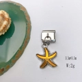 Detailed macro view of a yellow starfish alloy charm for Italian style charm bracelets - Model 127-Starfish