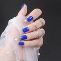 Short square bright blue press-on nails shown with elegant silver rings and pearls - Bright Blue (DFYL-04)