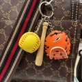 Detail of mini wooden bat, yellow baseball and orange glove keychain on a bag - Yellow Ball Orange Glove Black Strap