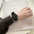 Minimalist black quartz watch with round dial and matching strap on a model's wrist - Large Size - Numeric Black Dial