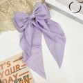 Detail of lavender satin hair bow clip with long streamers on a stylish aesthetic background - Purple