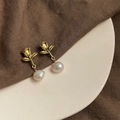 Close-up of golden rose stud earrings with natural baroque pearl drops on ceramic plate - Style 7 - Silver Earring Post