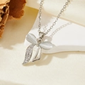 Detail of silver bow necklace featuring white cat eye stone and sparkling pavé crystals - Silver White Stone Bow Single Diamond Style (T015)