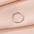 Primer plano de un anillo minimalista de acero de titanio plateado pulido sobre tela rosa - US 6 / Plateado