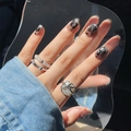 Dark aesthetic short press-on nails with black rhinestones and silver rings on denim background - Black Irregular Gem Glue Style (D-81)