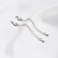 Close-up of platinum plated extension chains with lobster clasps and teardrop pendants - White Gold Color Drop Style