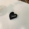 Detail of a small black heart-shaped acetate hair claw clip for a minimalist hair style - Approx. 4cm / Glossy Black