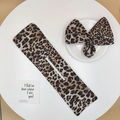 Detailed view of leopard print hair bun maker and matching bow scrunchie on white table - Brown Small Leopard