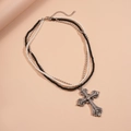 Macro detail of triple-layer necklace featuring pearls and a rhinestone cross pendant - Black White Silver Triple Layer Style