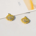 Macro detail of yellow shell charms with colorful rhinestones and gold alloy rings - Shell / Yellow