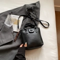 Borsa a secchiello nera in pelle con manico e ciondolo intrecciato in stile moderno - Nero