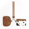 Dettaglio del set con pochette in finta pelle marrone, porta carte muccato e cinturino intrecciato - Mucca Marrone