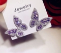 Detailed close-up of butterfly earrings with purple zircon and white crystal inlays - White Gold Purple Zirconia