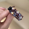 Détail d'une pince à cheveux avec des strass brillants violets et irisés - Violet Multicolore