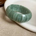 Detail view of light green resin elastic bracelet with marble texture on ceramic plate - Green