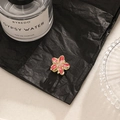 Pink and gold gradient frangipani flower hair clip on black textured paper setting - Red