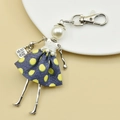 Detail of handmade doll keychain with blue polka dot dress and pearl head on white plate - 06-Dark Blue Polka Dot Doll