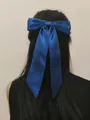 Dark blue satin bow hair clip with long ribbons styled on long dark hair - Duckbill Hair Clips / Blue
