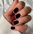Glossy black square-round press-on nails shown in a close-up on a white fabric background - Solid Black Glossy Short Squoval Style (CW281)