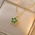 Detailed close-up of rotating gold bauhinia flower pendant with green zircons - Necklace / Emerald Green Bauhinia (X1310)