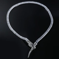 Détail du collier serpent argenté serti de zircons sur une surface noire réfléchie - Argenté