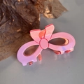 Detailed 45-degree view of pink hollow bow hair claw clip with glossy acrylic finish - Bowknot-Pink