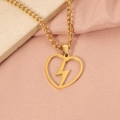 Detail view of a gold heart pendant with lightning bolt on a pink silk background - Gold