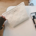 Detailed close-up of quilted white clutch featuring simple wish embroidery and soft shell texture - Shell Embroidery