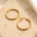 Pair of gold-finished twisted hoop earrings with a textured surface on beige stone - Braided Wire Texture Hoop Style (E128)