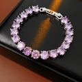 Vue macro d'un bracelet tennis en zircone cubique violette sur un coffret en cuir - Violet