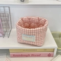 Detail of pink gingham quilted fabric storage basket with brand label on desk shelf - 12x10cm / Pink