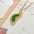 Detail of gold watermelon pendant with green zircons on vintage paper background - Green-Style 2