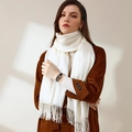 Elegant white cashmere-style winter scarf with fringe details worn over a wool coat - White