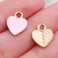 Pink enamel and gold leaf texture heart charms for DIY jewelry making displayed on a finger - Pink Heart (11023)