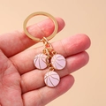 Llavero de baloncesto rosa con tres pequeños dijes en un anillo de metal dorado - Rosa