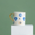 Ceramic coffee mug featuring blue evil eye and gold celestial patterns on a pedestal - Moon Stars Evil Eye Style (CF0163)
