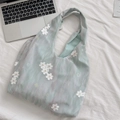 Close-up of mint green tulle tote bag with delicate white floral embroidery on soft fabric - Green