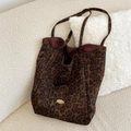 Detailopname van de canvas shopper met luipaardprint op een witte stoffen bank - Verticaal / Bruin