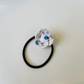 Gros plan sur l'élastique à cheveux fleur blanche avec taches roses et bleues - Graffiti au Crayon