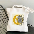 White canvas tote bag featuring yellow moon and female profile art on a black metal chair - STD438-B (Yellow Crescent with Profile)