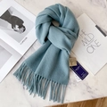 Light blue 100% pure wool scarf with fringe detailing on a white marble background - Grey Blue
