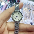 Detalle de reloj pulsera plateado para mujer con esfera blanca y manecillas azules - Caja Plateada Esfera Blanca