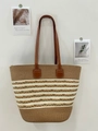 Brown and beige striped woven tote bag with leather straps hanging on a white wall - Brown Braid