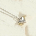 Macro-opname van een gepolijste 3D-hartjesketting aan een minimalistische zilveren ketting - Klein (1.5cm) / Zilver